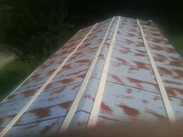Rusted metal roof panels with new wood purlins before replacement — Storm Damage Roof Repair in Harwood by Roofing Brothers