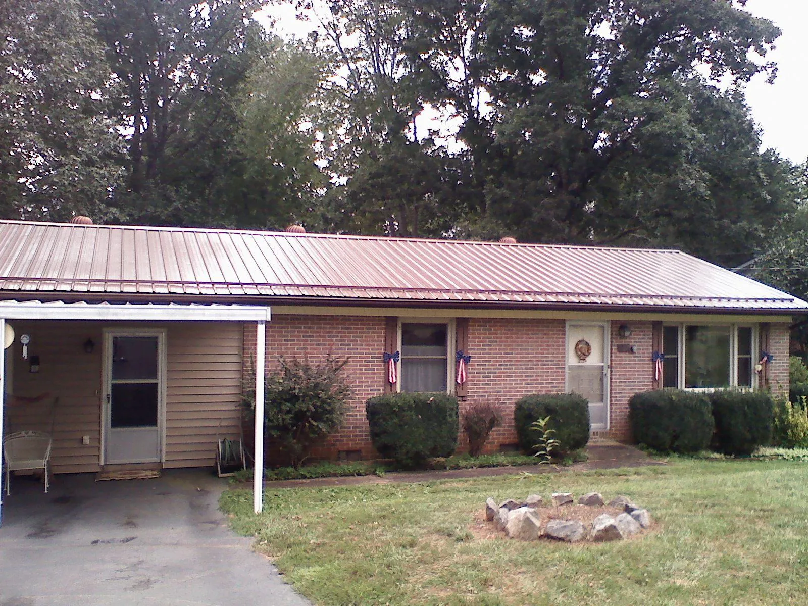 Bronze metal roof and carport on a brick ranch home — Roof Repair work by our crew in Harwood